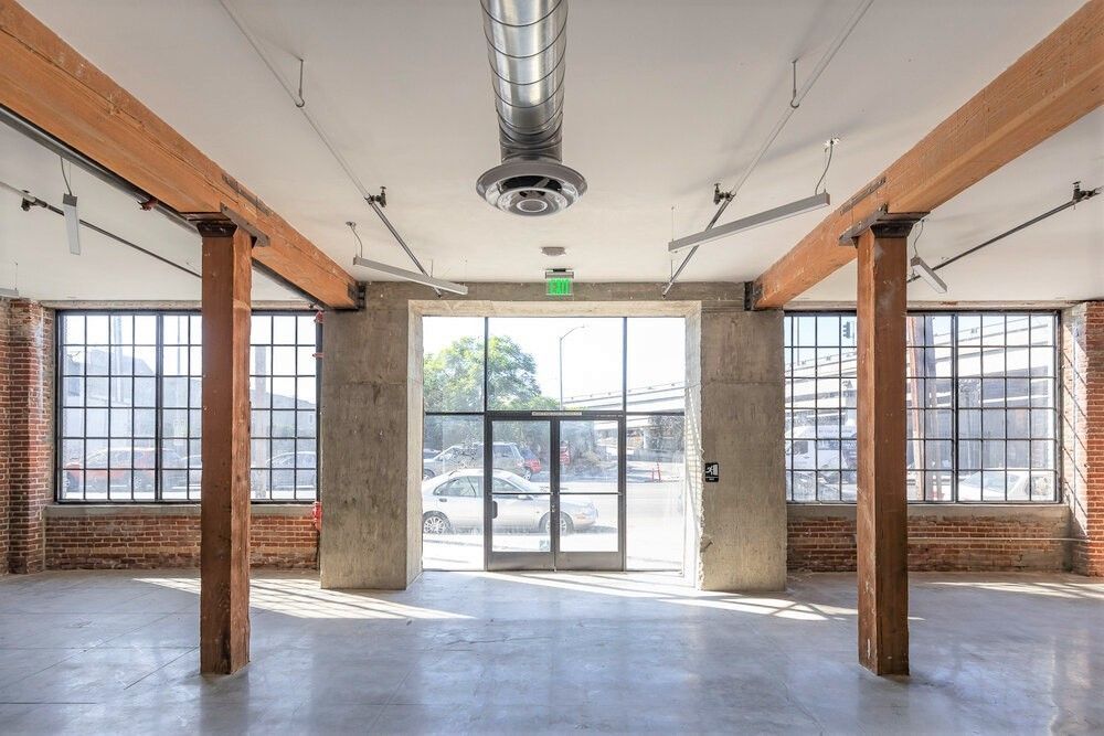 An empty room with a lot of windows and wooden beams