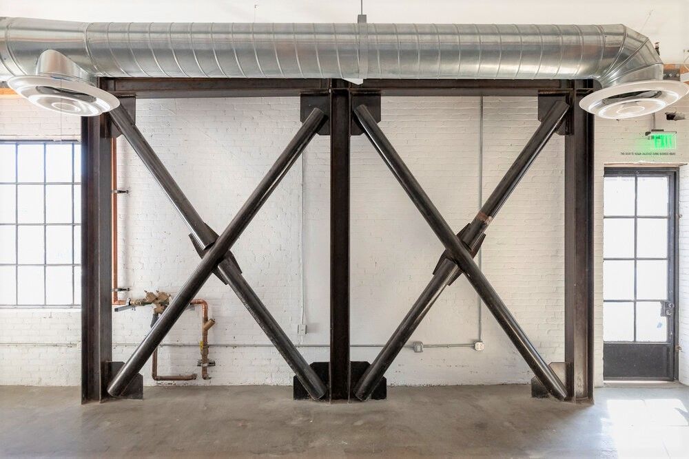 An empty room with a large metal structure in the middle of it.
