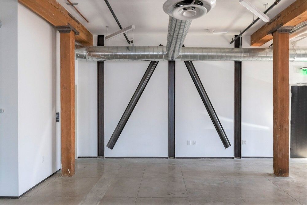 An empty room with white walls and wooden beams