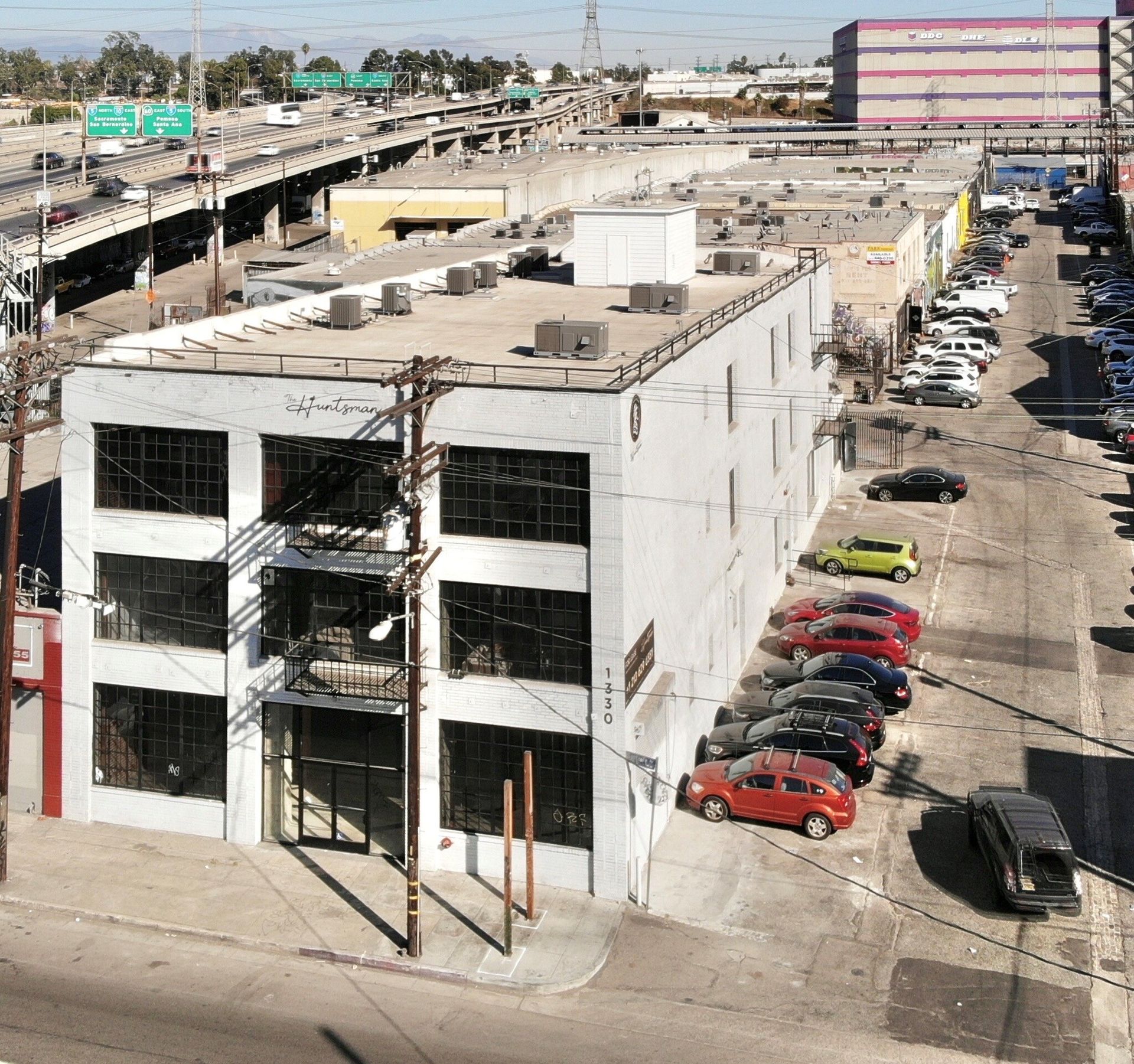 An aerial view of a building with cars parked in front of it