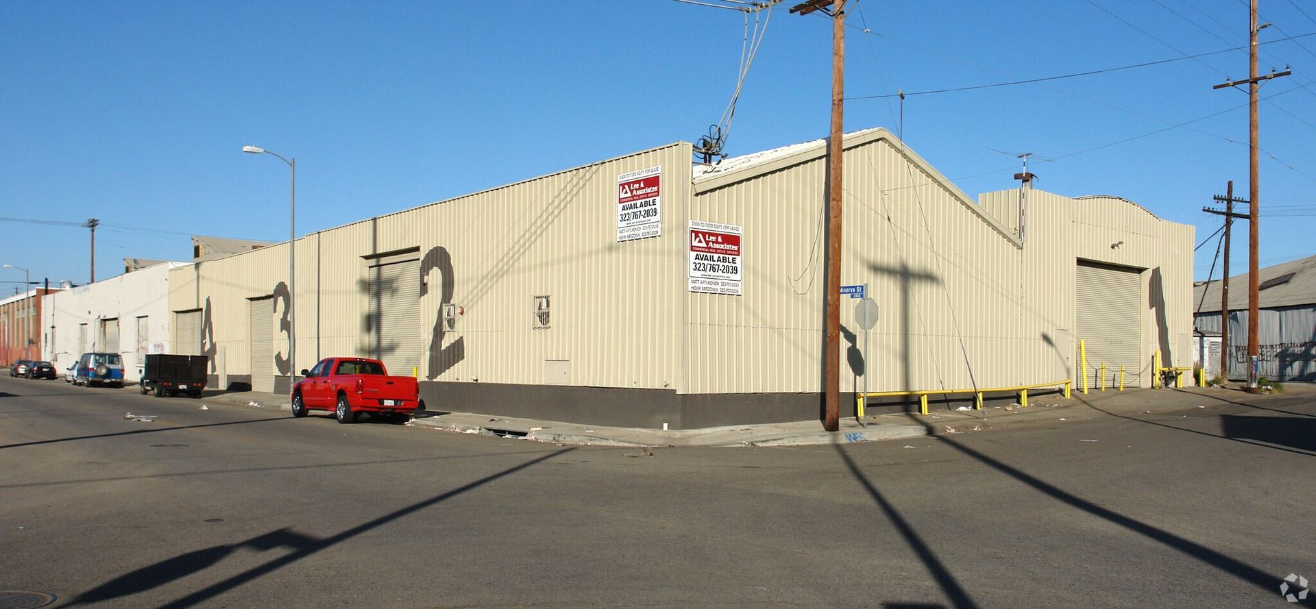 A red truck is parked in front of a large building