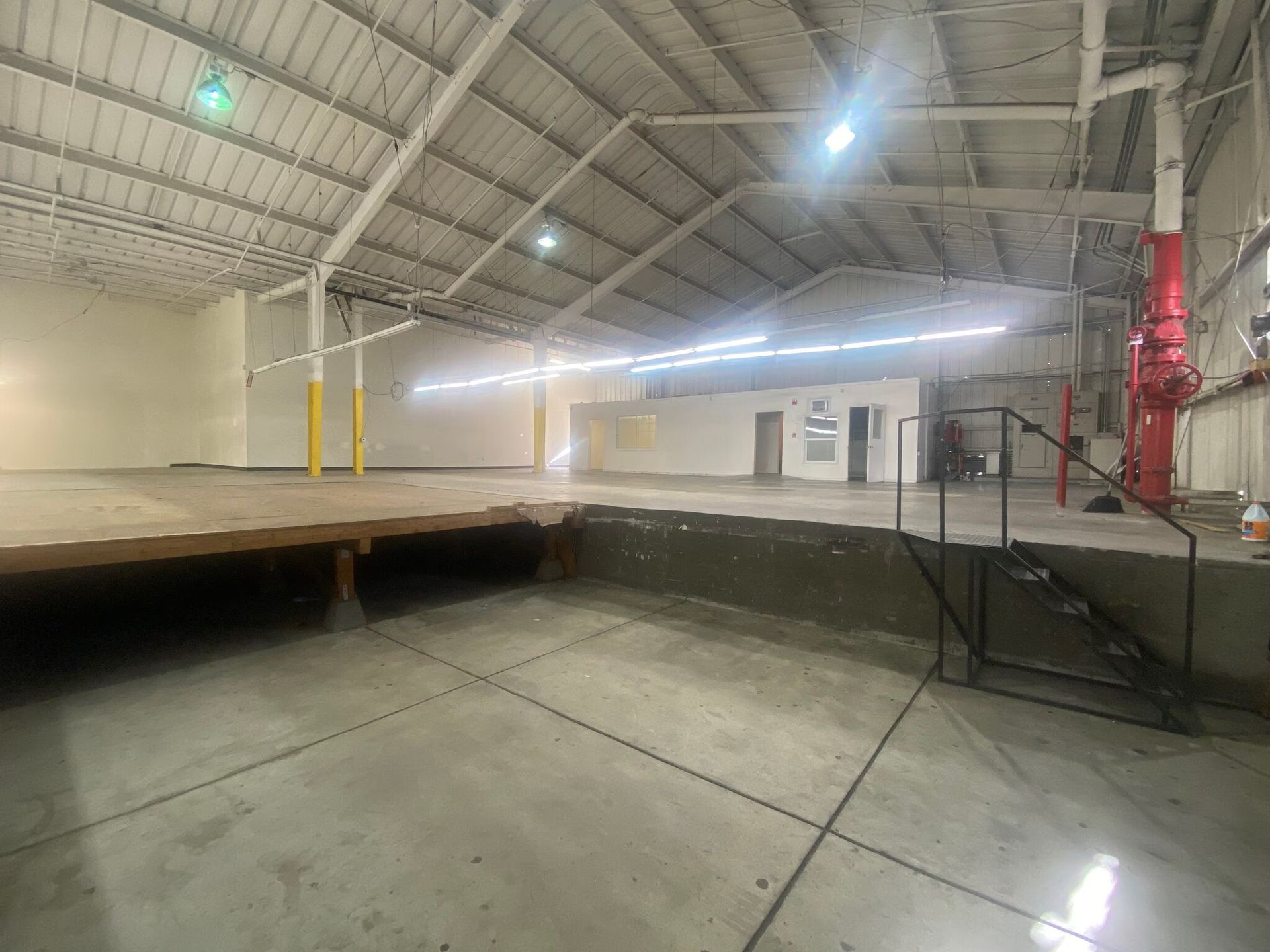 A large empty warehouse with stairs leading up to it.