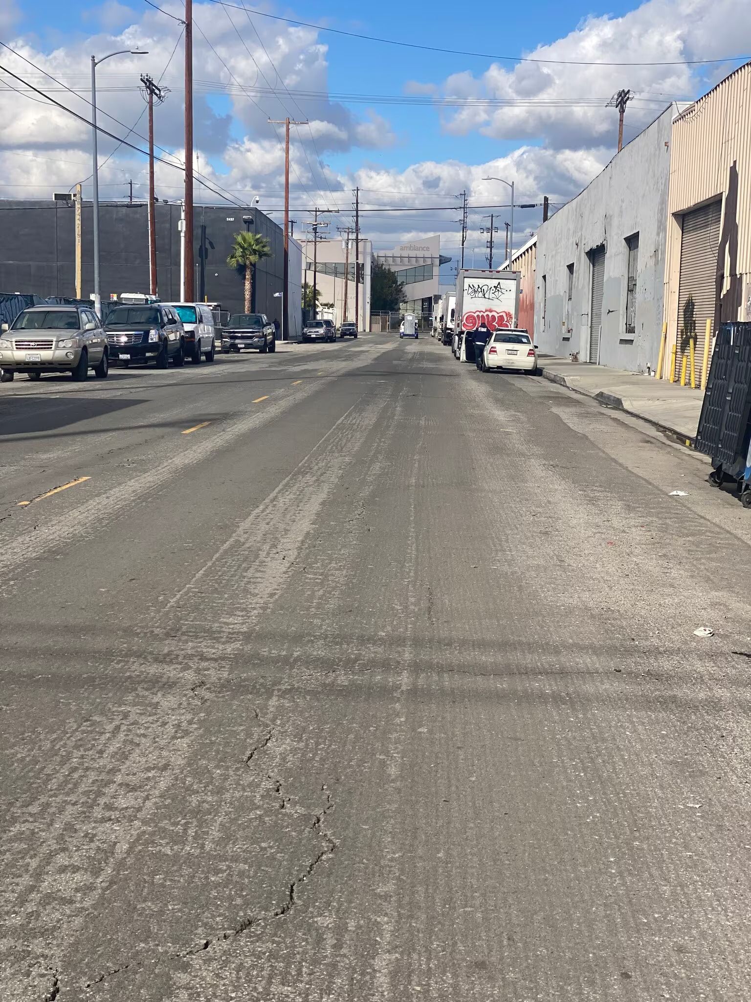 A row of cars are parked on the side of a street