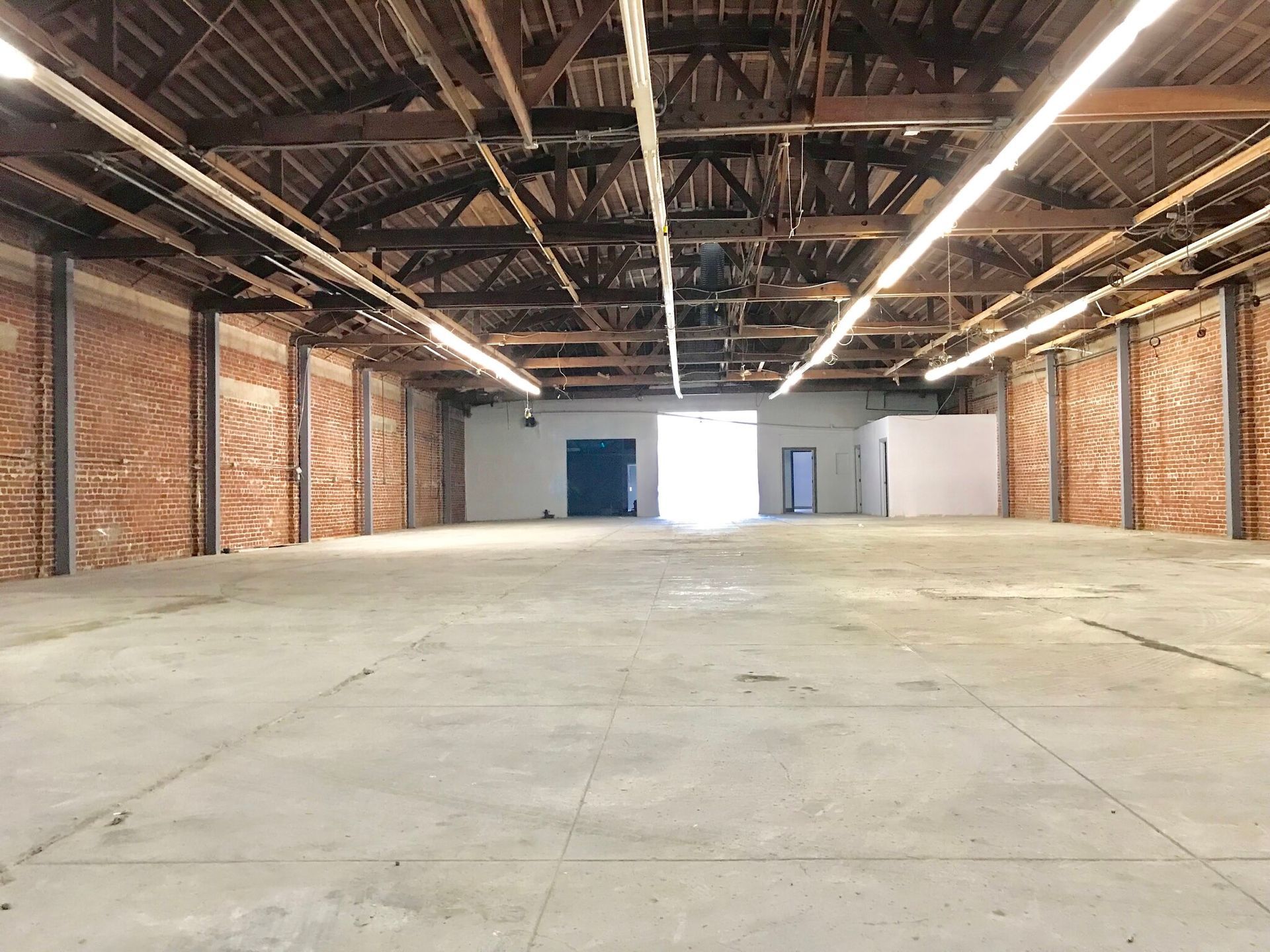 An empty warehouse with brick walls and a concrete floor