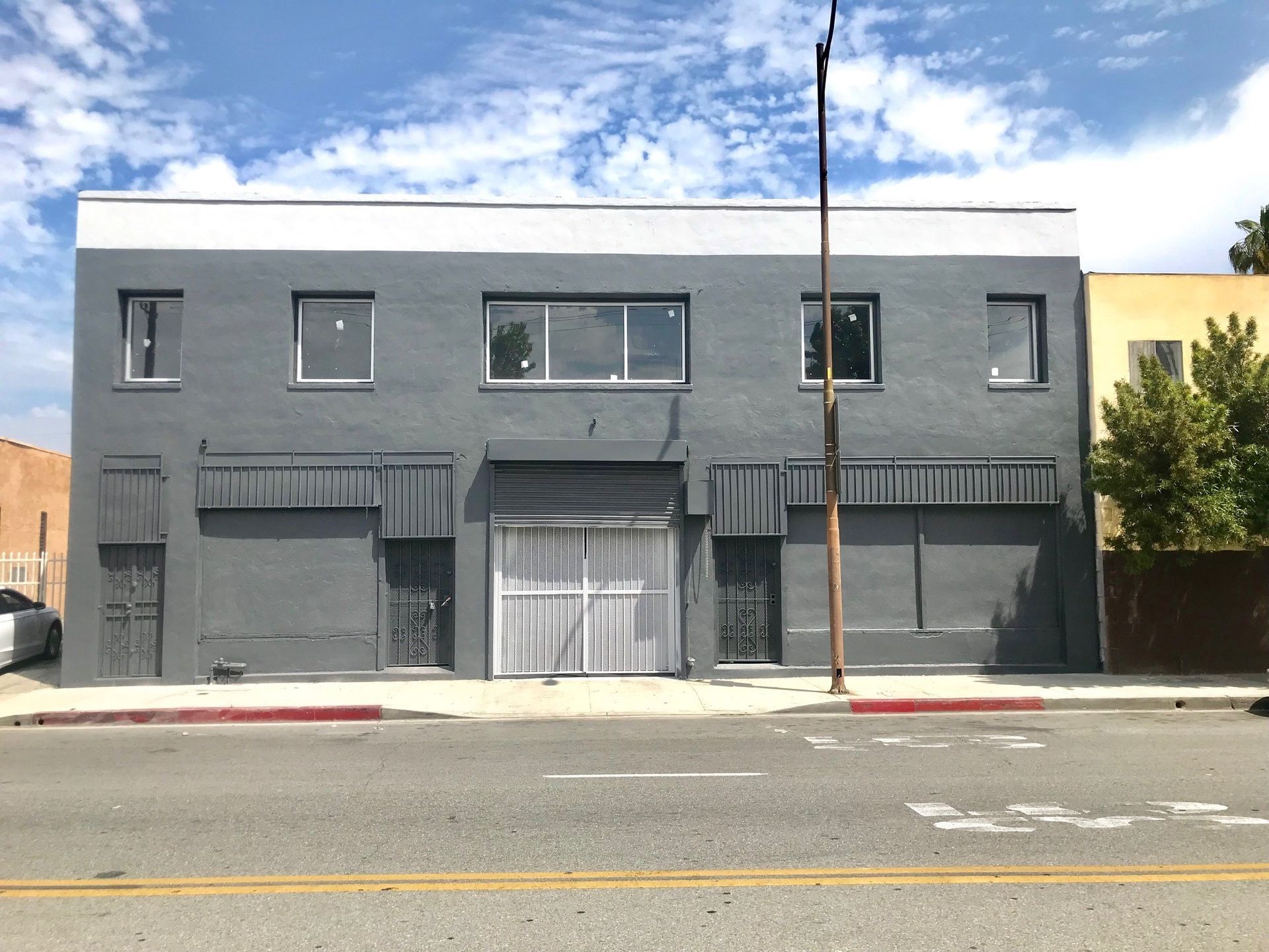 A gray building with a garage on the side of it