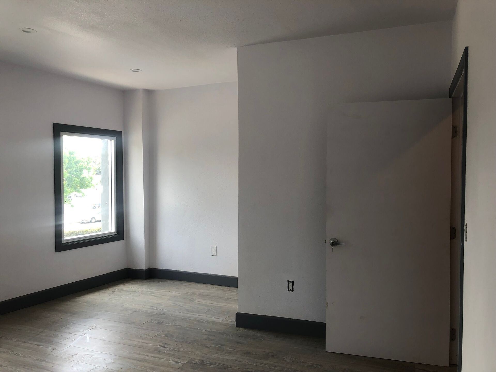 An empty room with a window and a door.