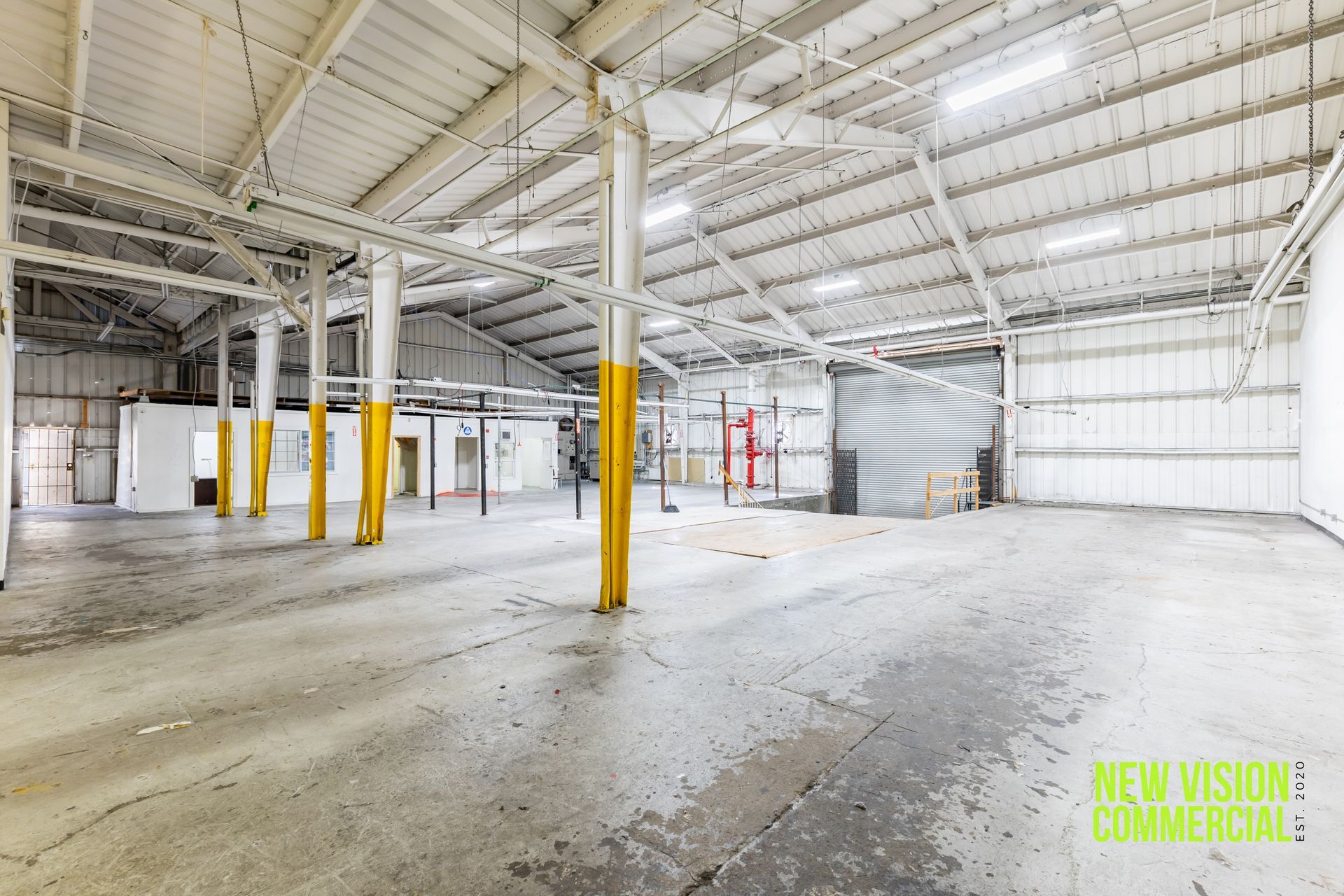An empty warehouse with a sign that says we 're vision commercial