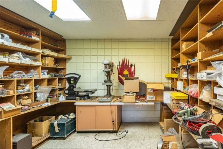 A room filled with lots of shelves and a desk.