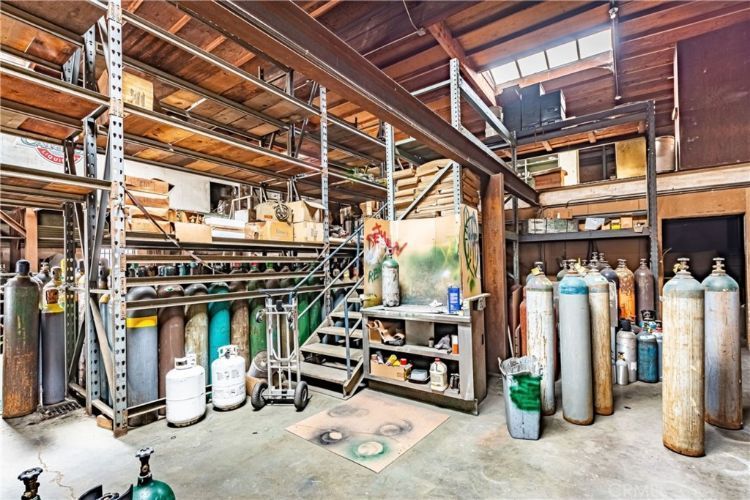 A warehouse filled with lots of gas cylinders and stairs.