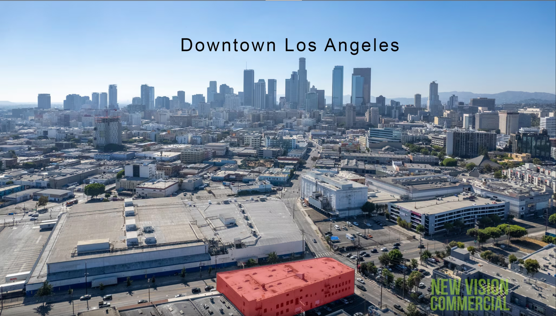 An aerial view of downtown los angeles with a red building in the middle