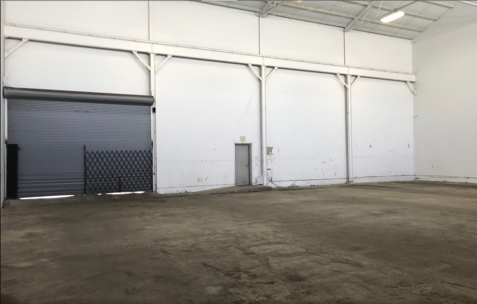 A large empty warehouse with a blue garage door