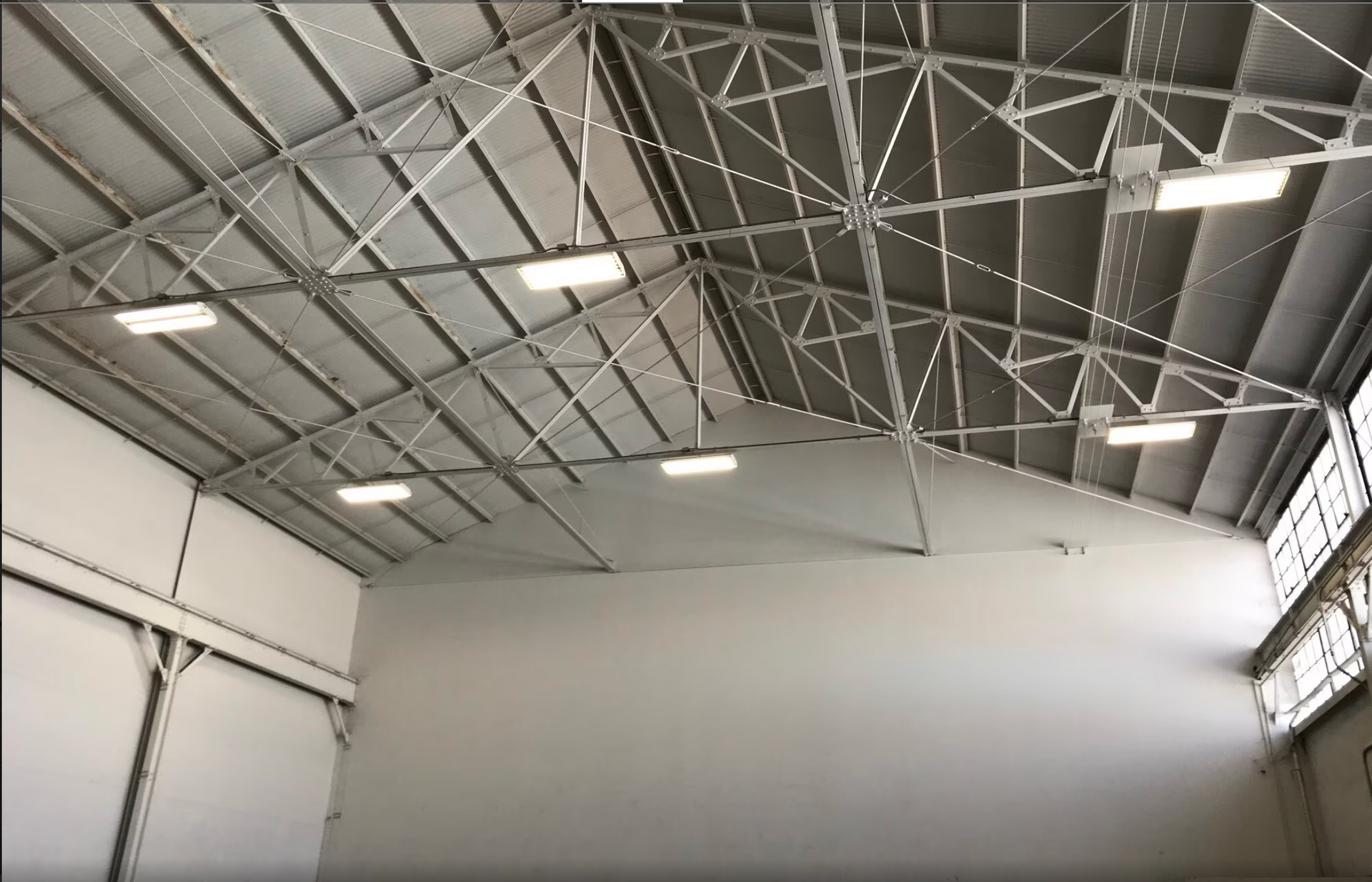The inside of a large building with a metal roof