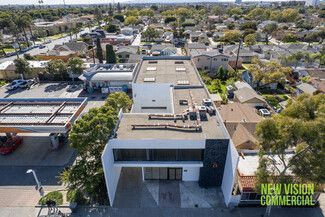 An aerial view of a building with a gas station in the background.