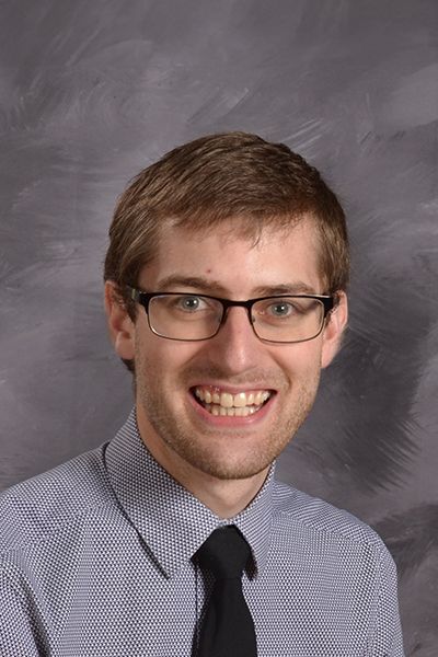Head shot of Nathan Schleef in his shirt and tie, smiling at the camera