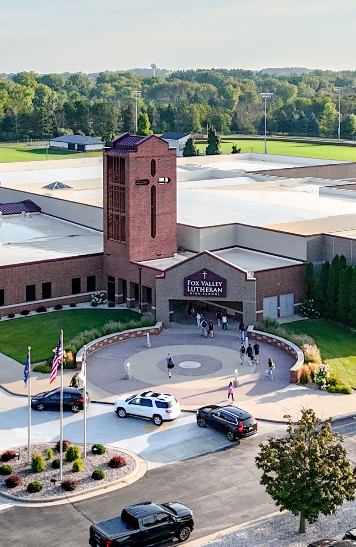Drone image of the tower entrance of the school with cars dropping off students.