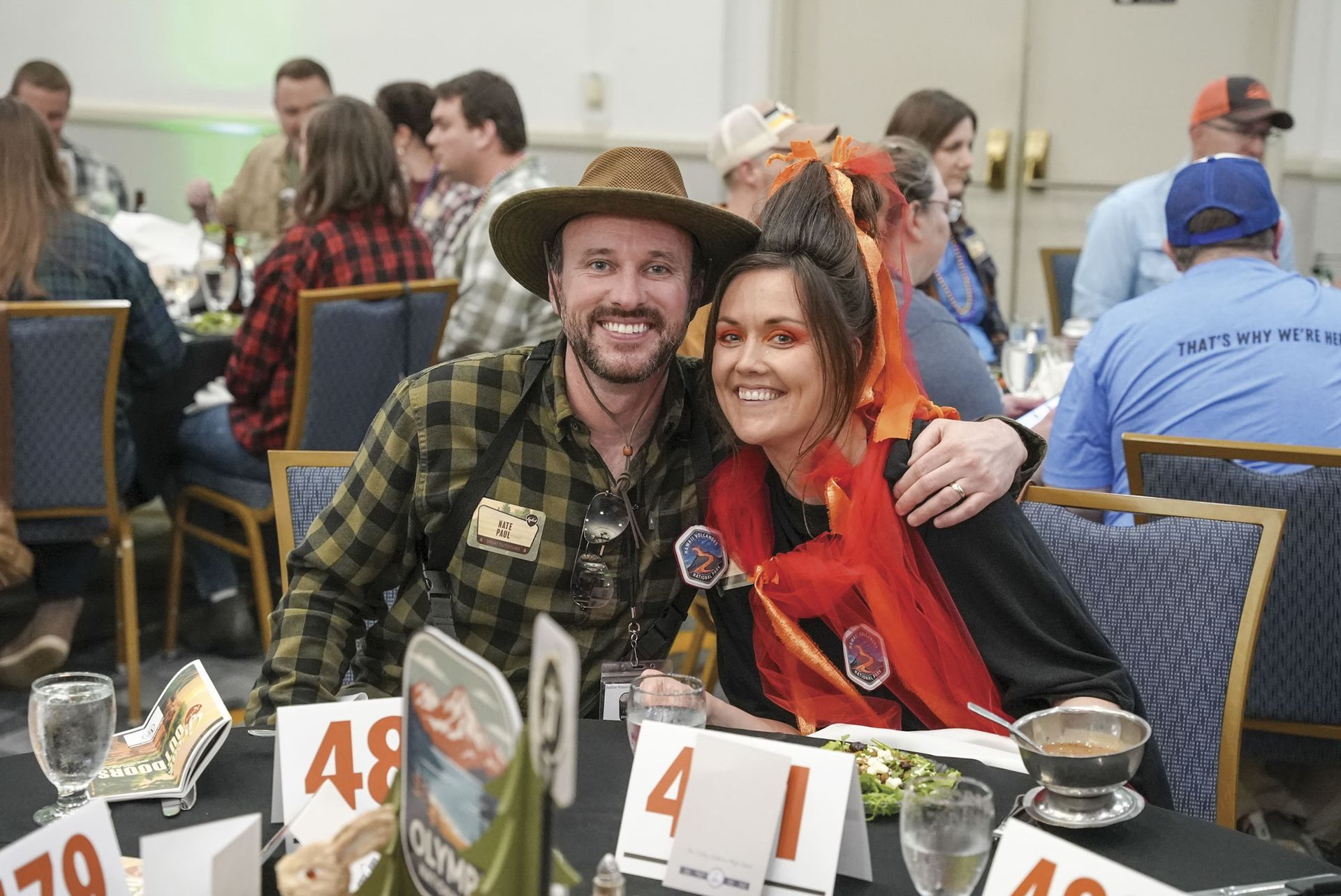 Male and female attendees at their table, dressed in 