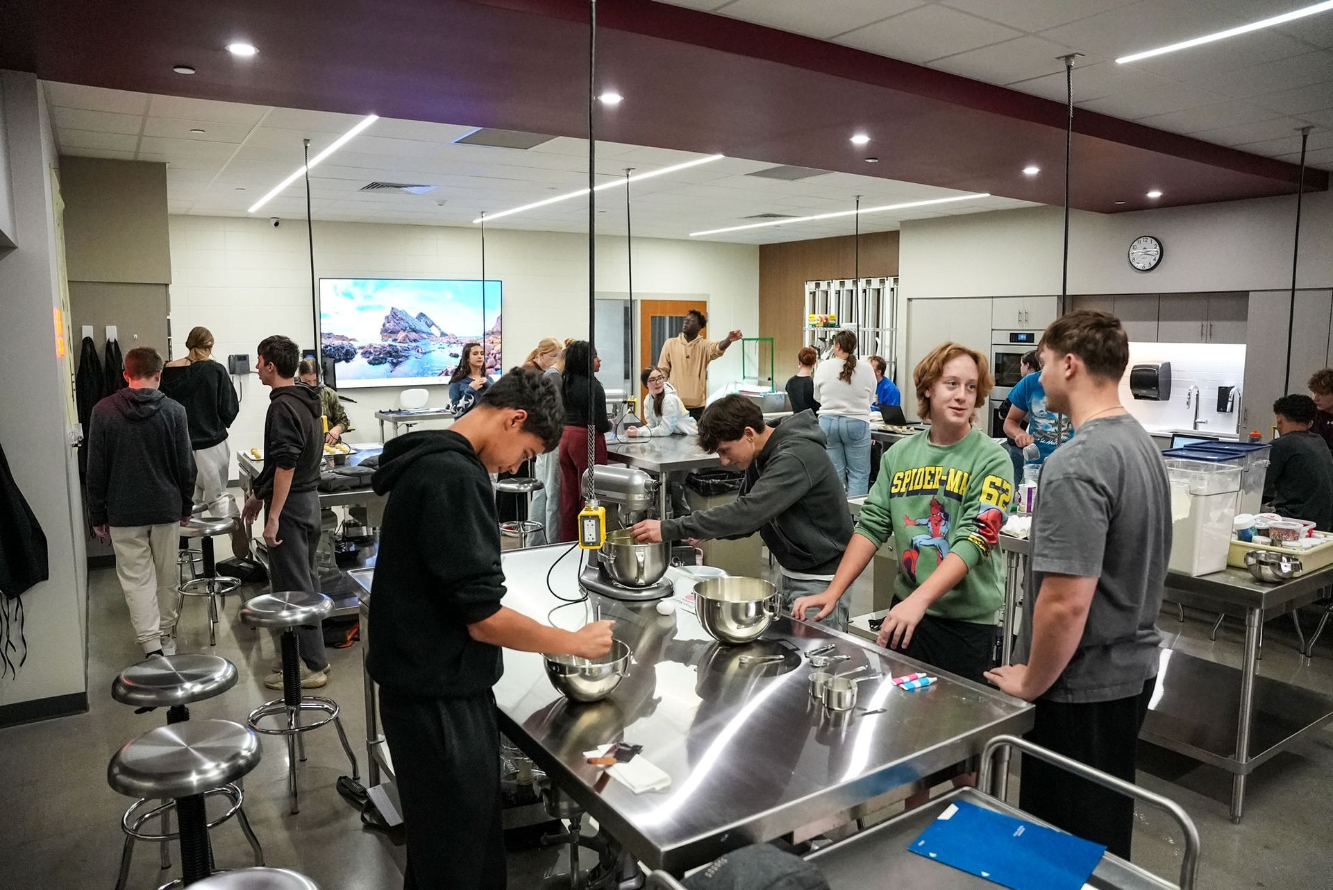 Culinary Arts Lab with stainless steel tables, and students working at the stations.