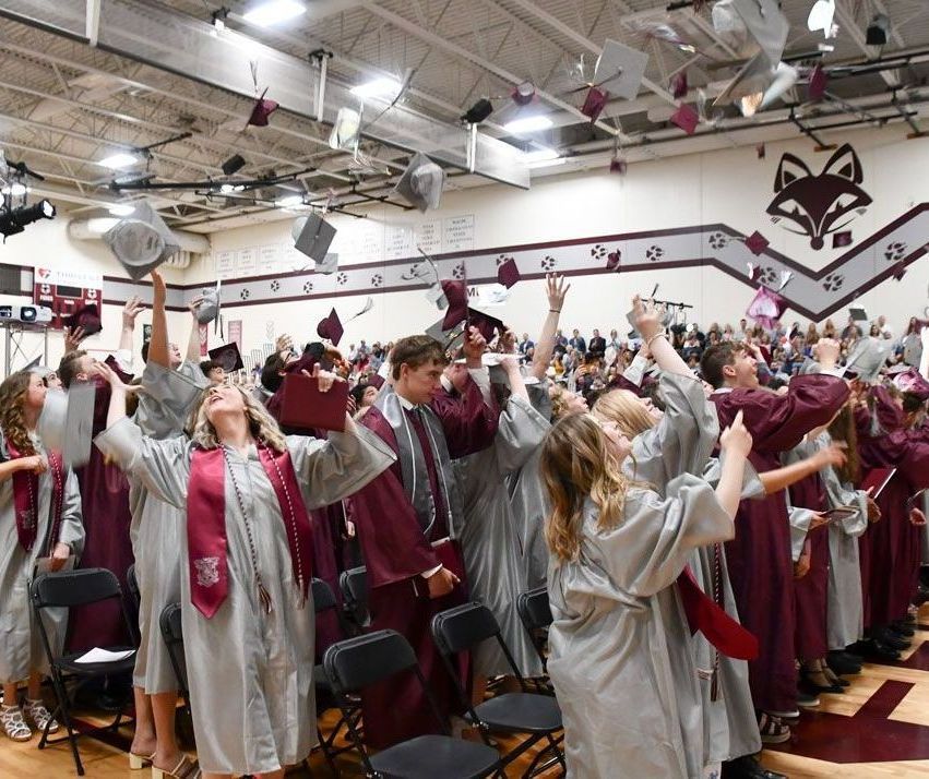 Post-graduation mortar board toss in the gym