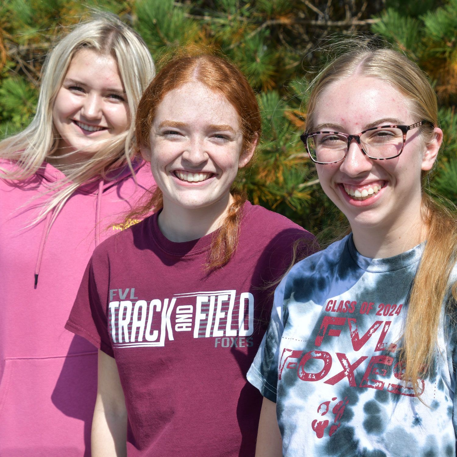 Three smiling girls outside