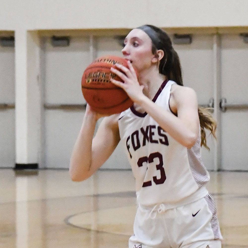 Emily Jaenke, on the court and in uniform, ready to shoot a basket