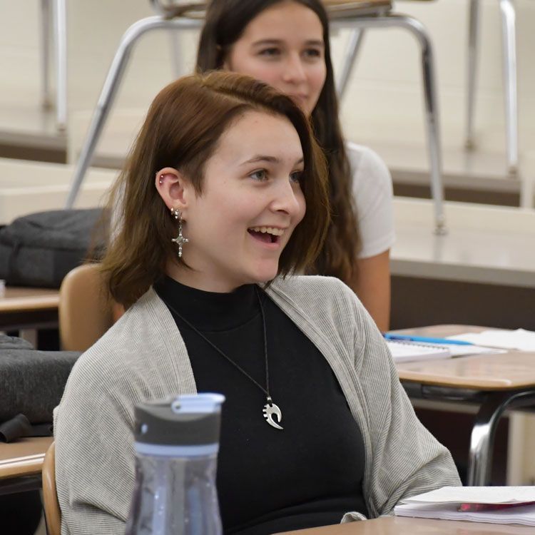 Happy female student sitting in a desk