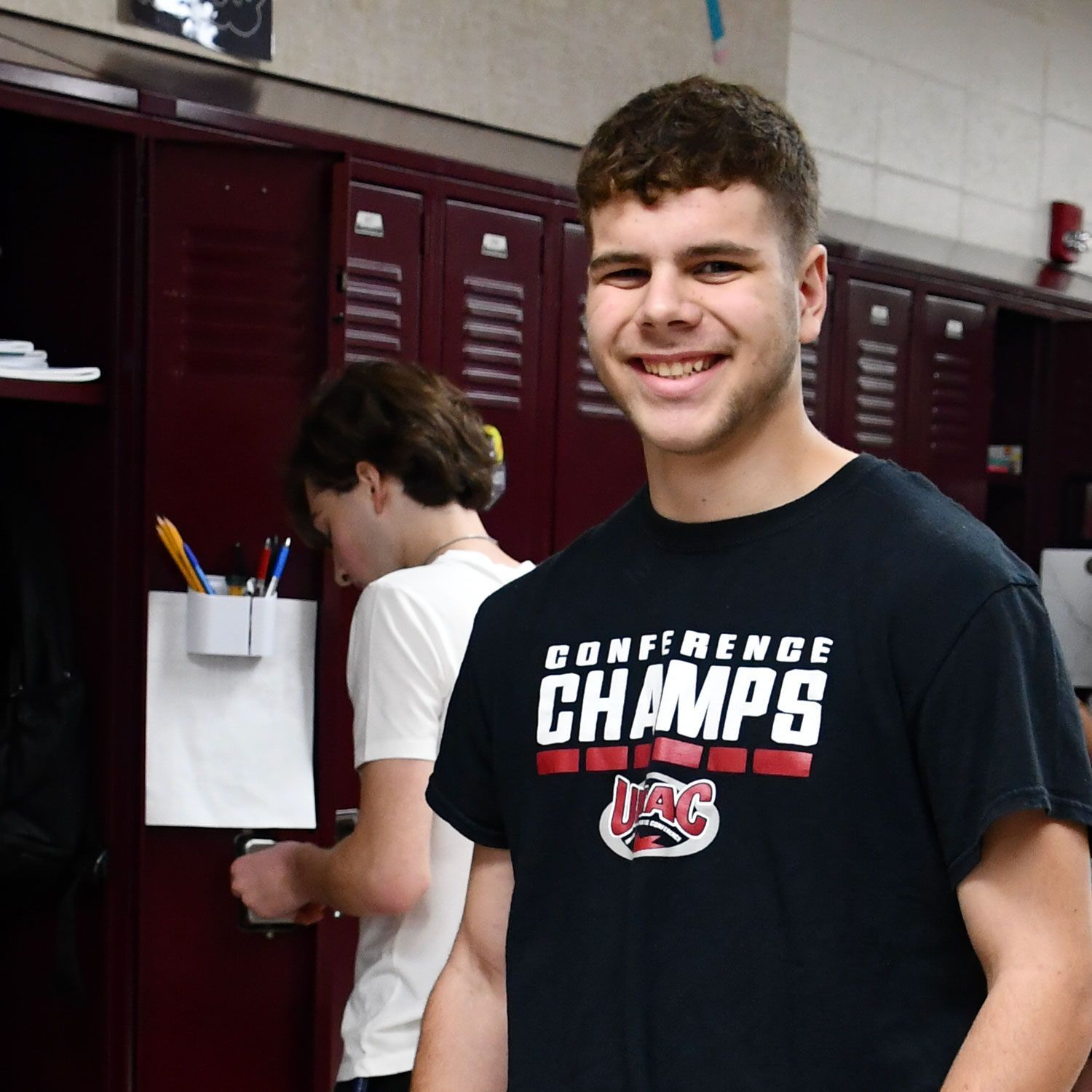 Smiling student standing in front of lockers