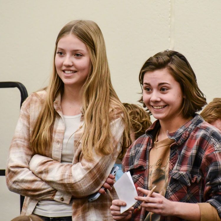 Smiling senior and freshman girls in the choir room