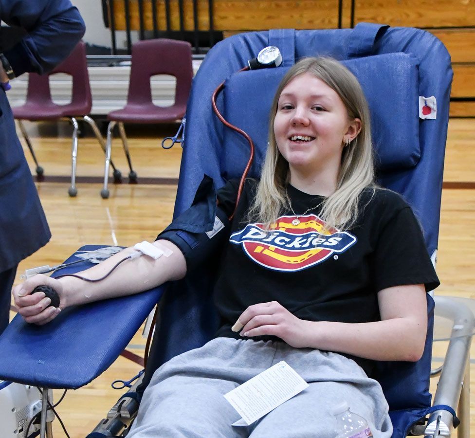 Happy female student donating blood