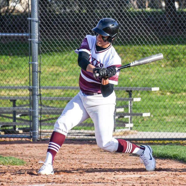Baseball player taking a swing at the ball at home plate
