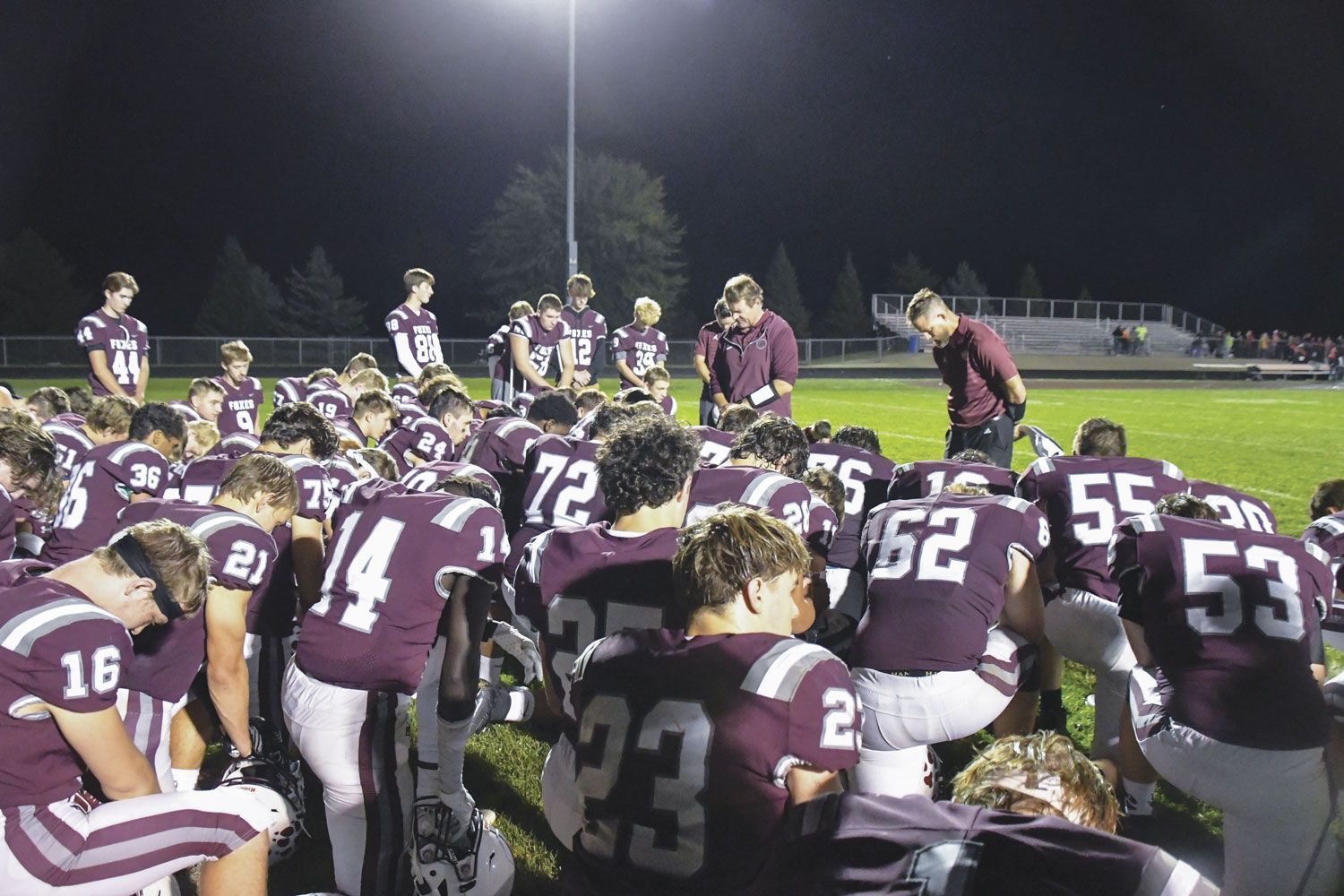 Football team praying after a game