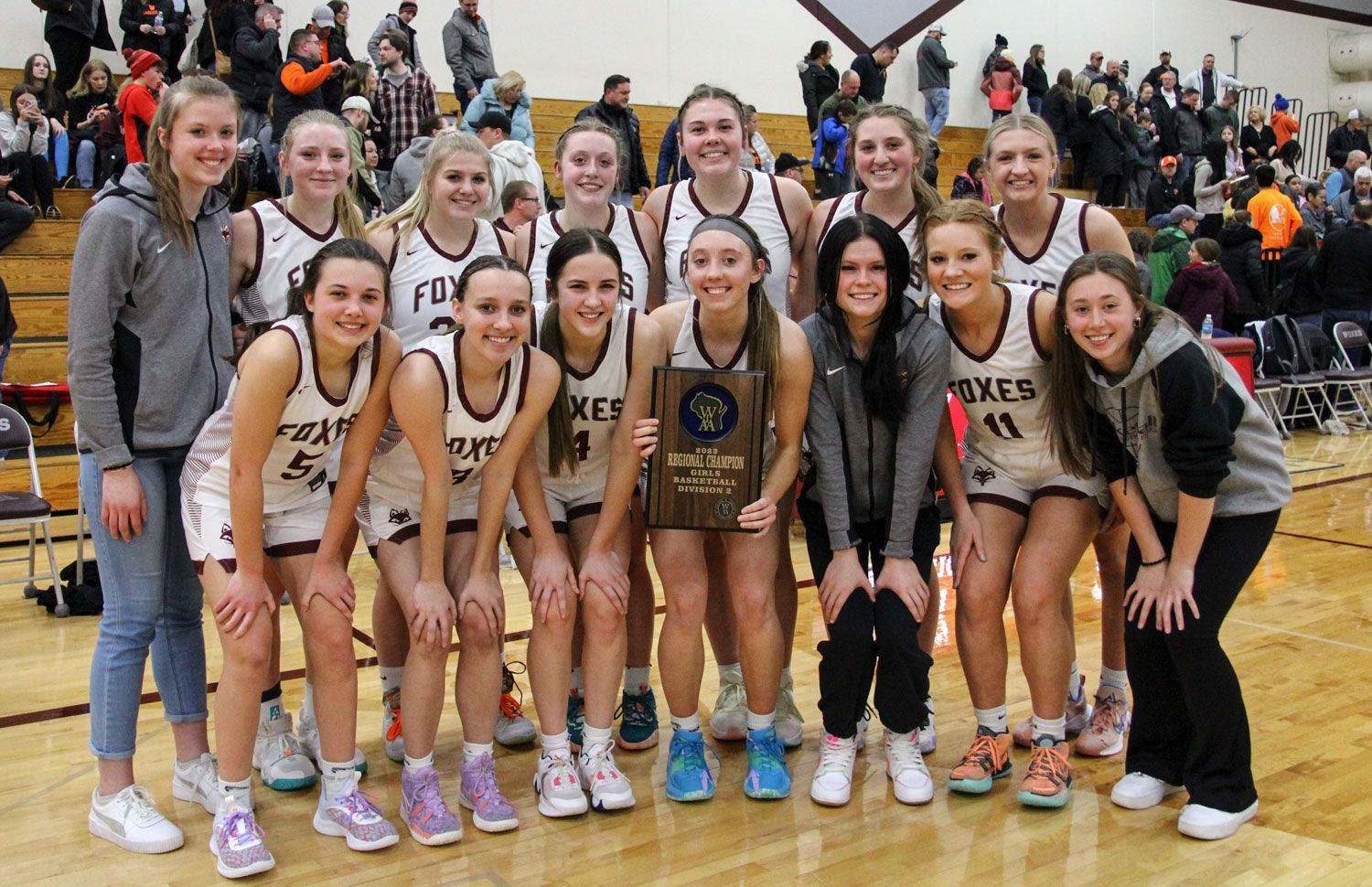 Girls basketball team holding their 2nd place conference plaque