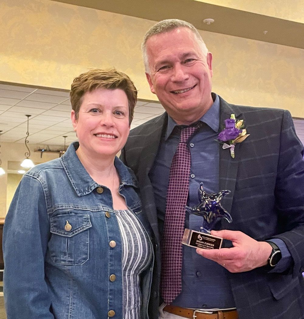 Smiling Brian and his wife, Deb, Zunker. Brian is holding his Shining Star award.