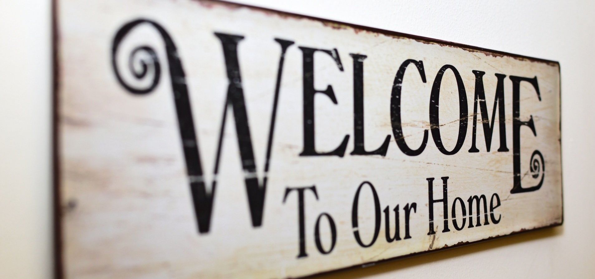 Sign with a wooden look that says Welcome to our Home