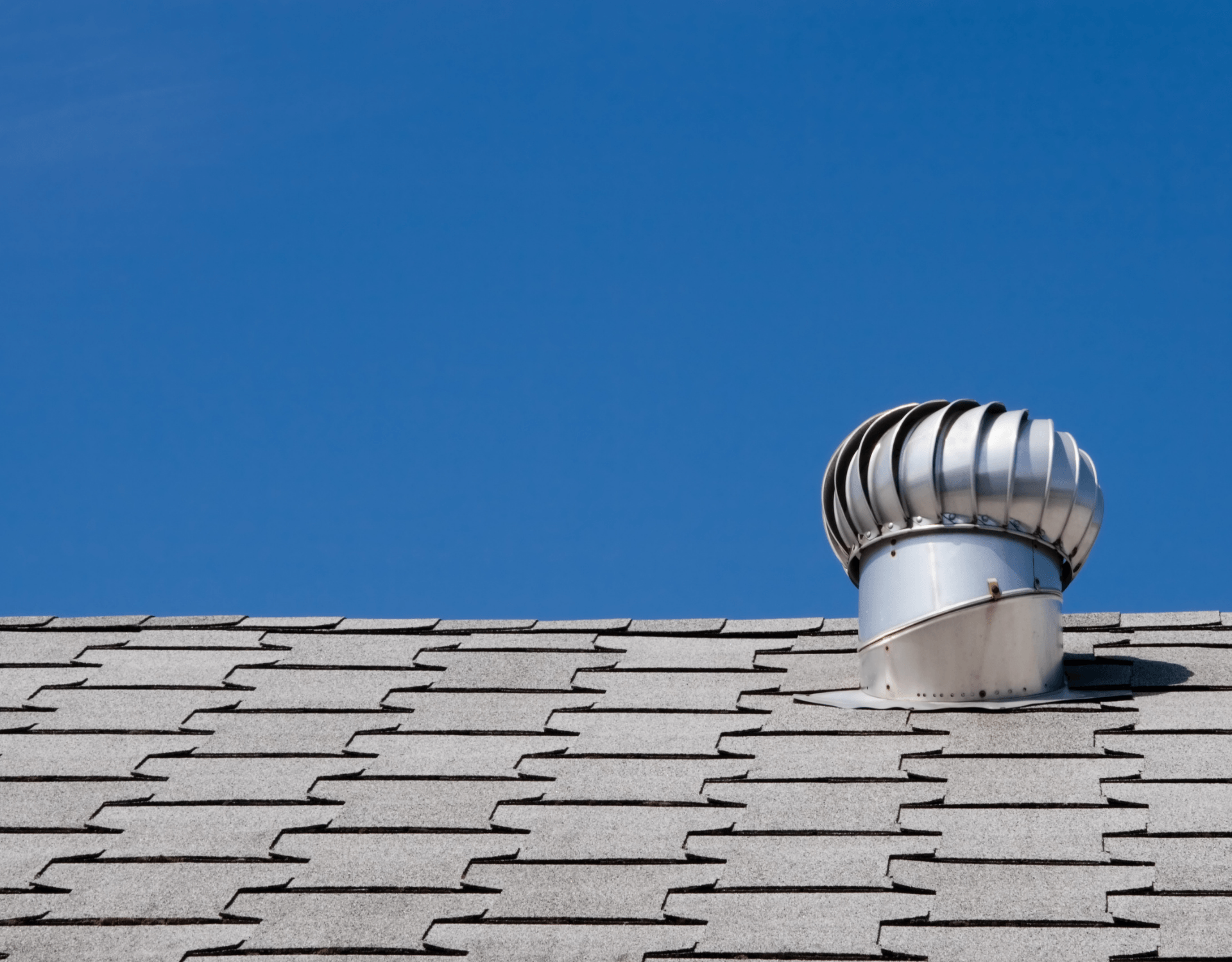 Metal roof vent against a clear blue sky