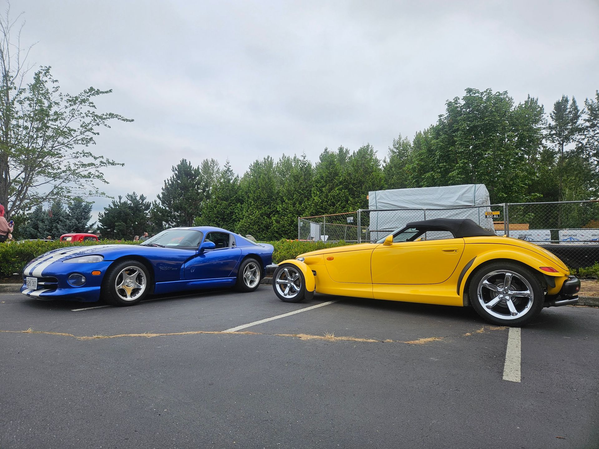 Classic cars displayed in a garage showroom, including green, red, and white vintage vehicles.