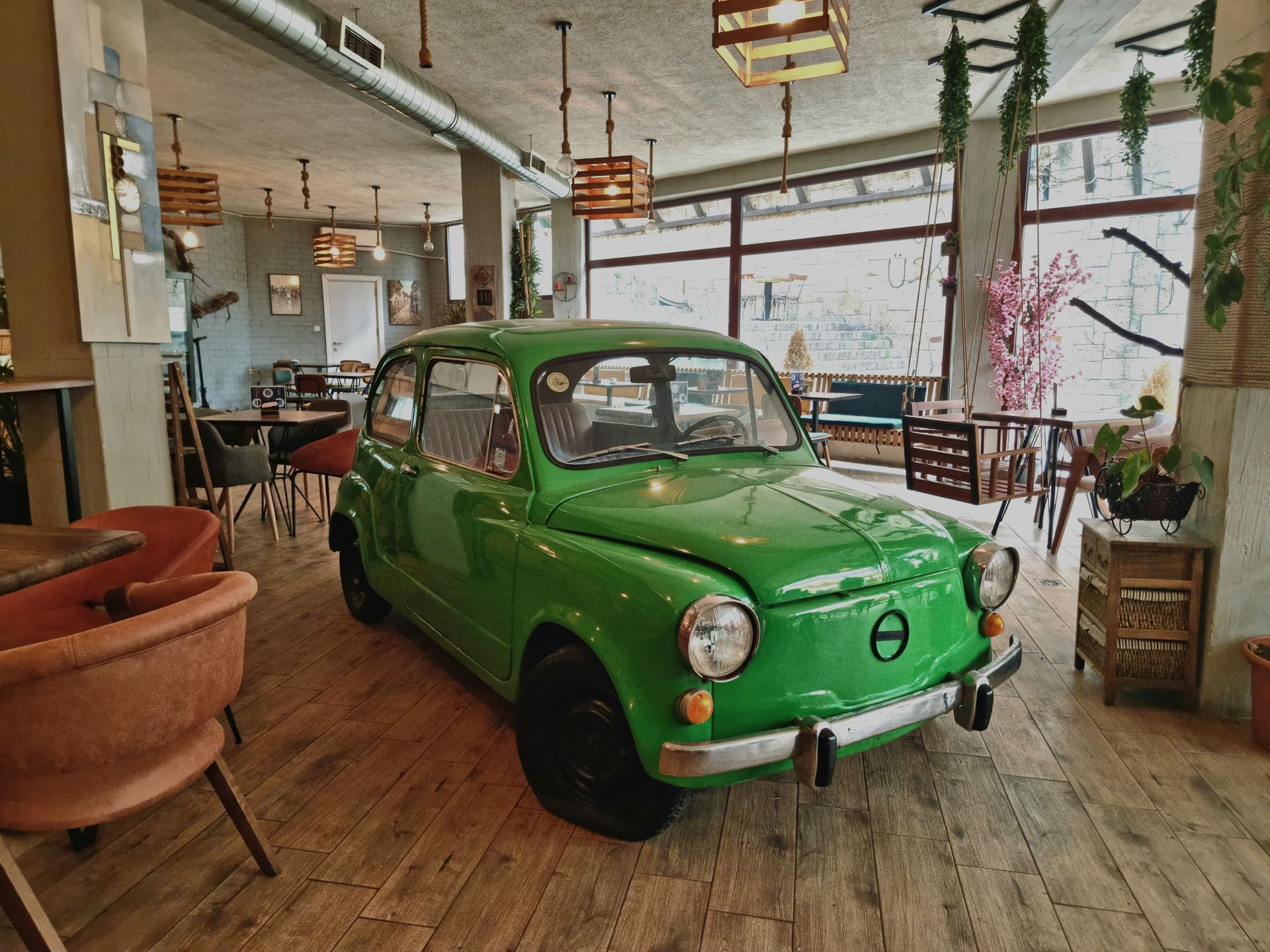 Open-plan restaurant interior with wooden tables, mezzanine seating, and warm industrial lighting