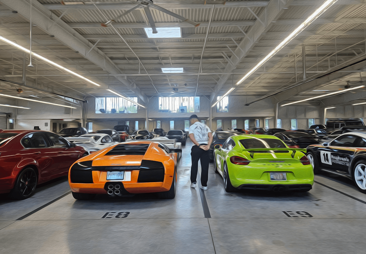 Classic cars displayed in a garage showroom, including green, red, and white vintage vehicles.