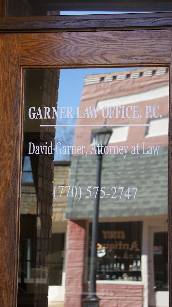 Glass office door with white lettering for Garner Law Office PC and attorney David Turner