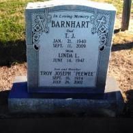 A headstone inscribed with the Barnhart family name, including T.J., Linda L., and Troy Joseph