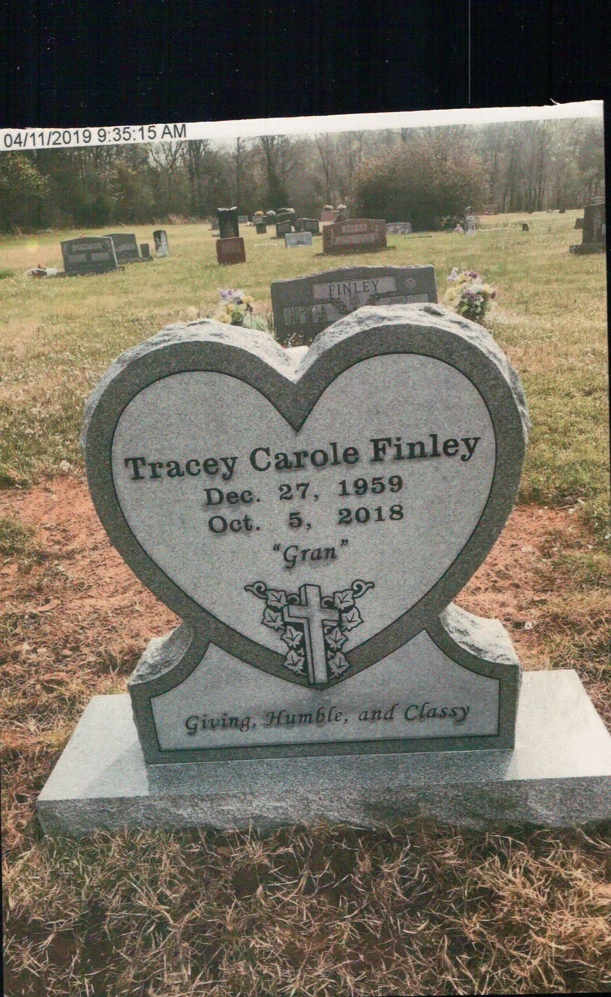 A heart-shaped gray granite headstone for Tracey Carole Finley (1959–2018), nicknamed 