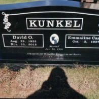 A black granite grave marker for David O. and Emmaline C. Kunkel, showing their birth and marriage dates and an epitaph.