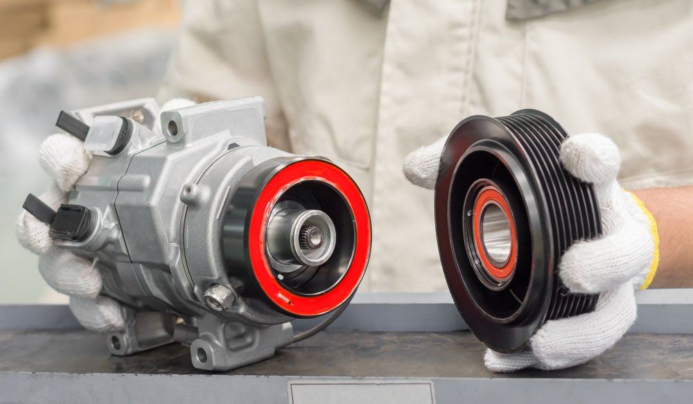 Mechanic Holding New Car Air Compressor — Automotive Batteries in Boonah, QLD
