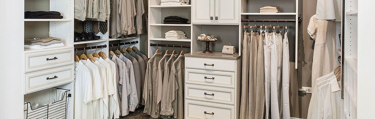 A walk in closet filled with lots of clothes and a dresser.