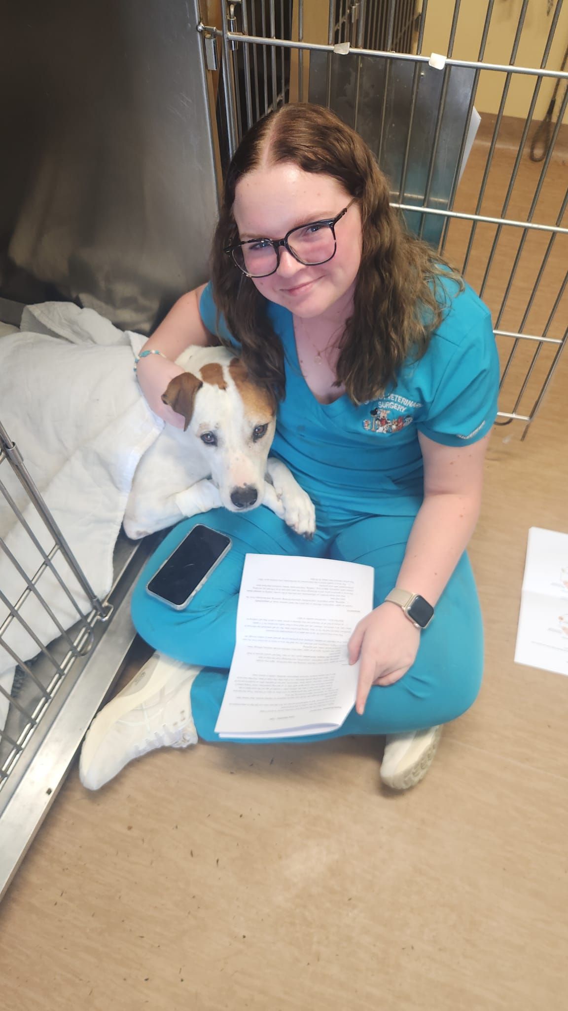 Woman in Teal Scrubs Holding a Small White-And-Brown Dog — Sarina Veterinary Surgery In Sarina, QLD