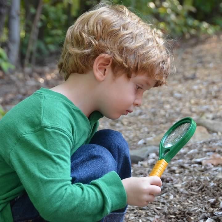 A boy looking through a magnifier glass
