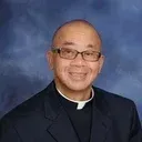 Silhouette of a person in a clerical collar on a light gray background