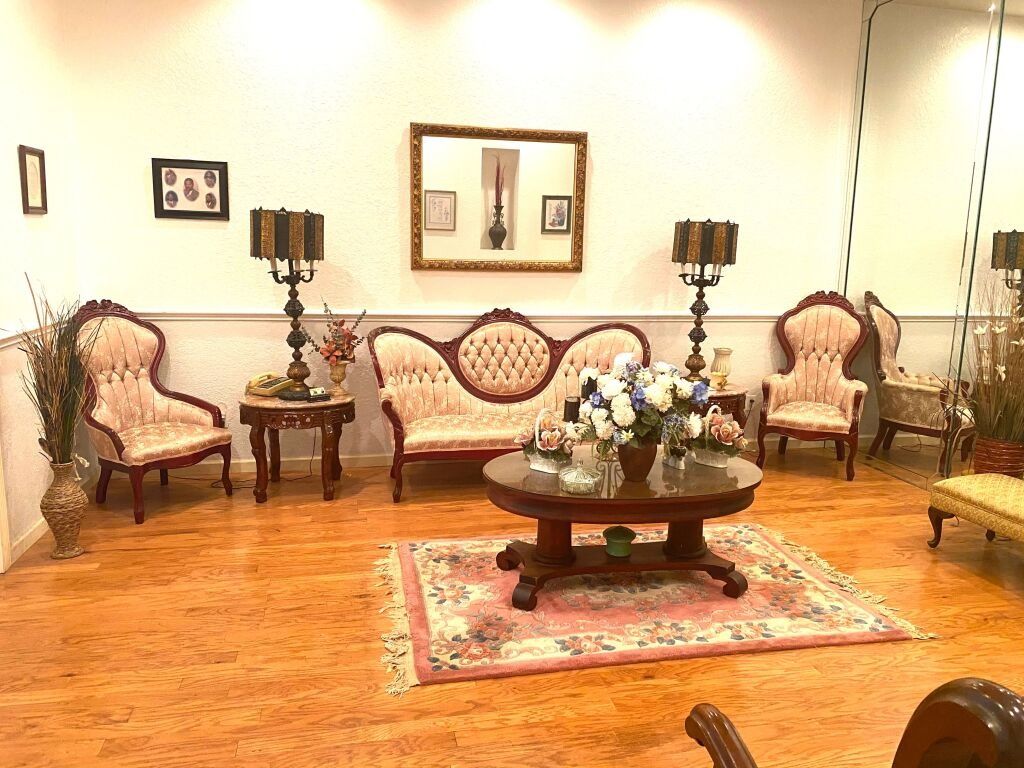 Living room with vintage furniture, gold frame art, a round coffee table, and area rug.