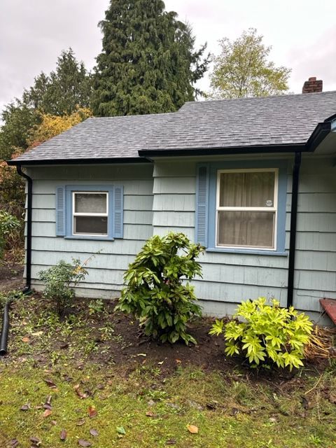 A small blue house with blue shutters on the windows