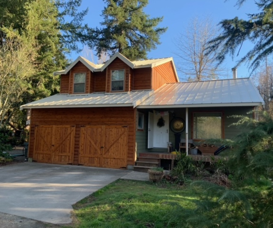 A house with a metal roof and wooden garage doors