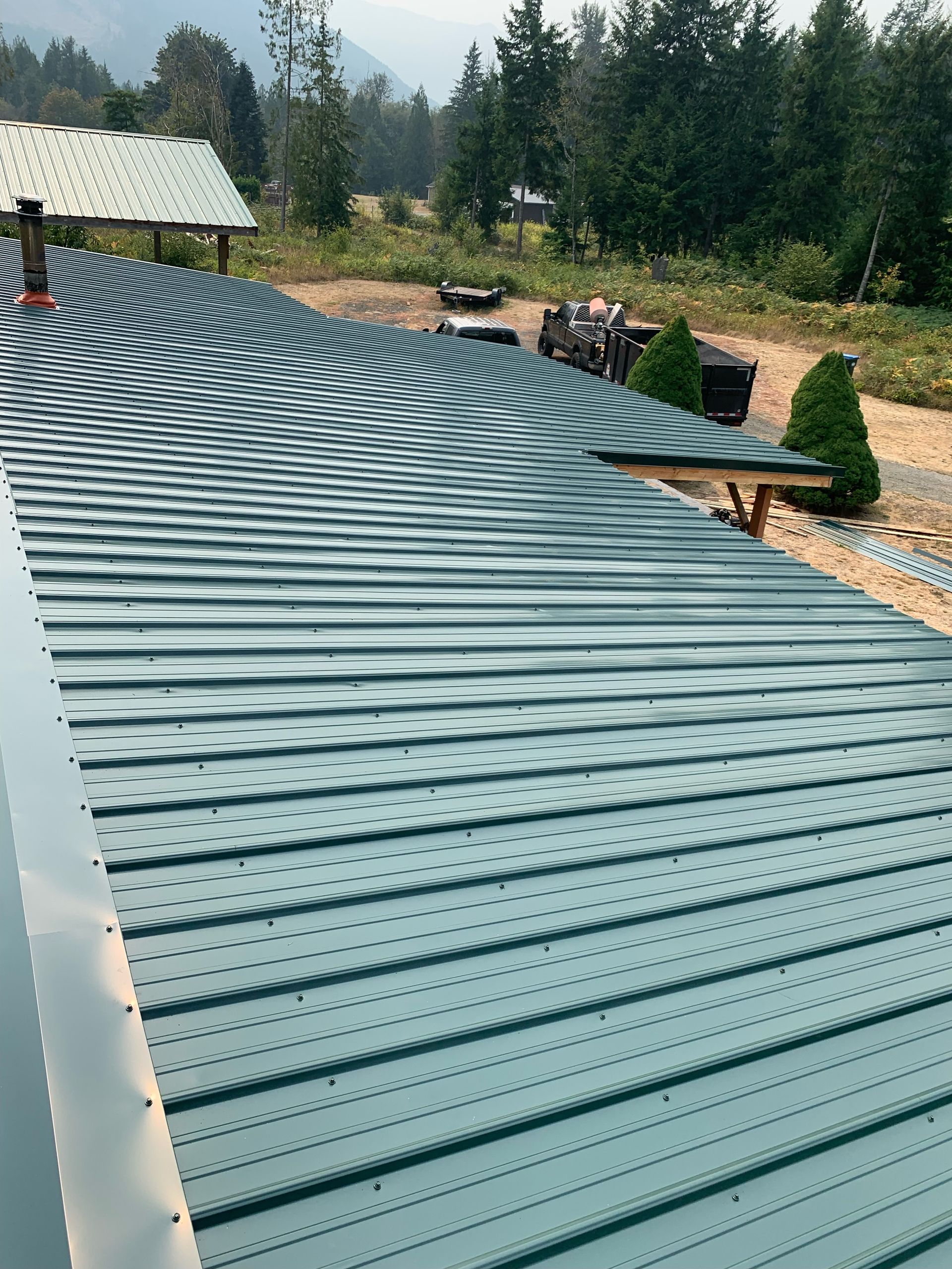 A close up of a roof with trees in the background.